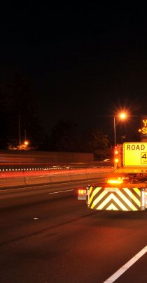 safety attenuator truck on highway road project at night