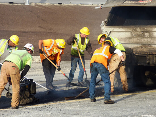 Road workers fixing pavement