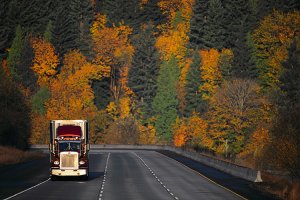 tractor trailer truck on mountain highway in autumn