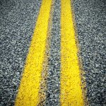 closeup of asphalt pavement and yellow lines