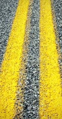 closeup of asphalt pavement and yellow lines