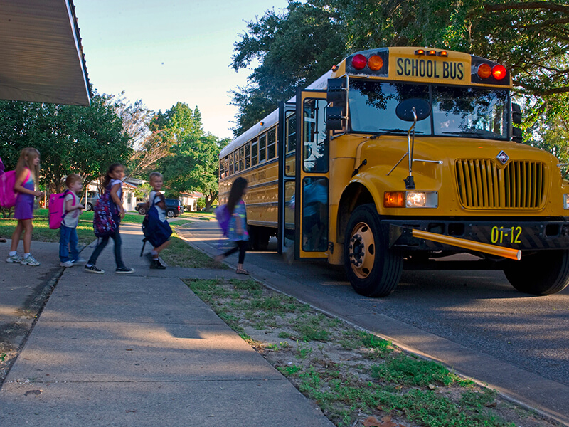 young students boarding a school bus