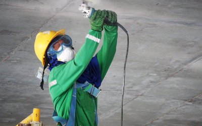 construction worker using a power grinder on concrete