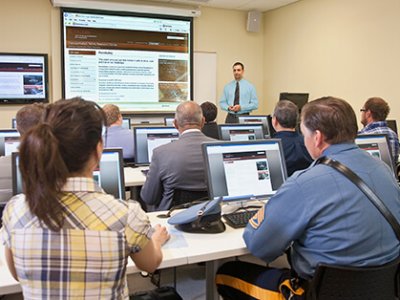 CAIT training facility with class attendees at computer workstations and instructor at front of classroom
