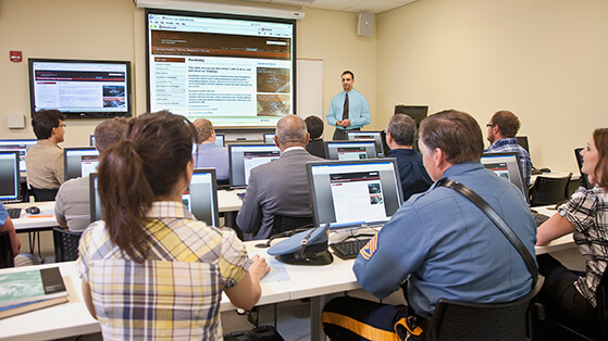 CAIT training facility with class attendees at computer workstations and instructor at front of classroom