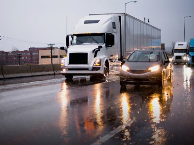 tractor trailer truck driving through a mixed residential-industrial area