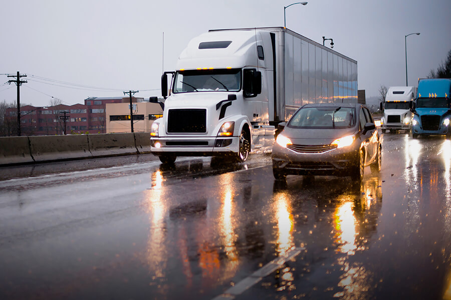 tractor trailer truck driving through a mixed residential-industrial area