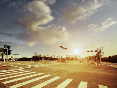 city intersection with crosswalk and signals on a hot summer day