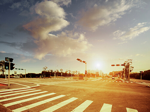 city intersection with crosswalk and signals on a hot summer day